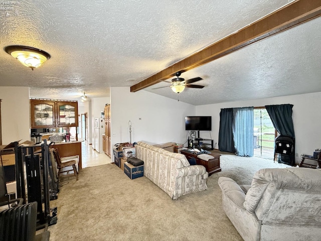 living room featuring ceiling fan, light colored carpet, beam ceiling, and a textured ceiling