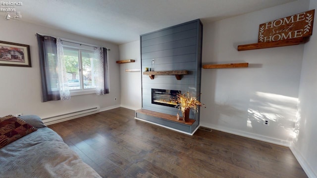 living room featuring a baseboard radiator, dark hardwood / wood-style flooring, and a large fireplace