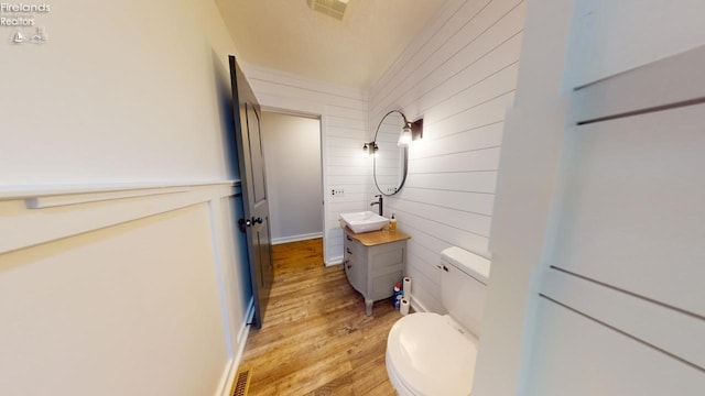 bathroom featuring toilet, vanity, and wood-type flooring