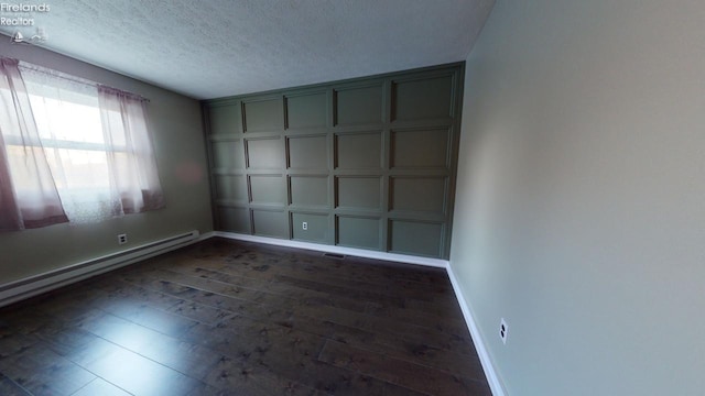 empty room with baseboard heating and a textured ceiling