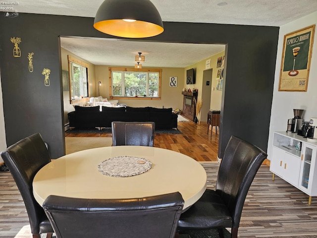 dining space with dark hardwood / wood-style flooring and a textured ceiling