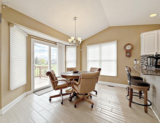 dining area featuring a notable chandelier, vaulted ceiling, and light hardwood / wood-style floors