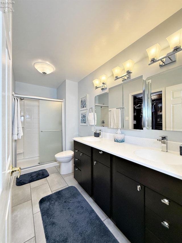 bathroom with a shower with door, tile patterned floors, vanity, and toilet