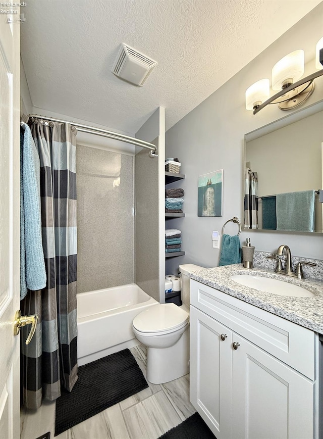 full bathroom featuring a textured ceiling, shower / tub combo with curtain, vanity, and toilet