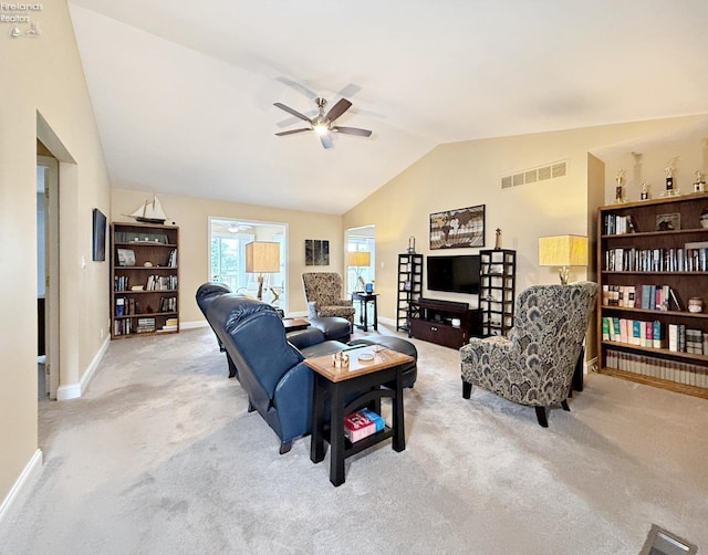 carpeted living room with ceiling fan and vaulted ceiling