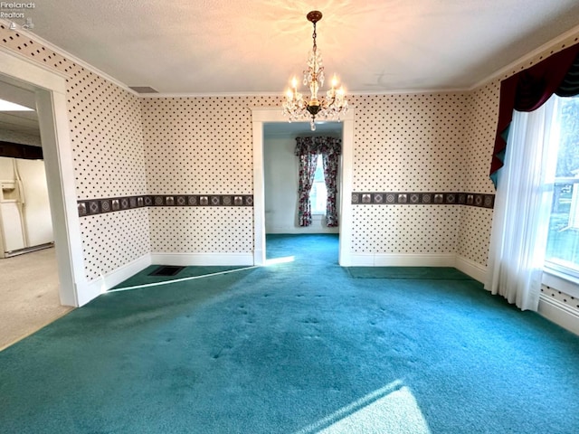 unfurnished dining area featuring a textured ceiling, ornamental molding, carpet floors, and a chandelier