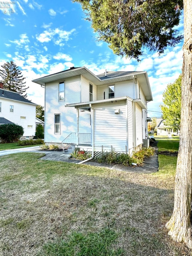 rear view of house featuring a yard