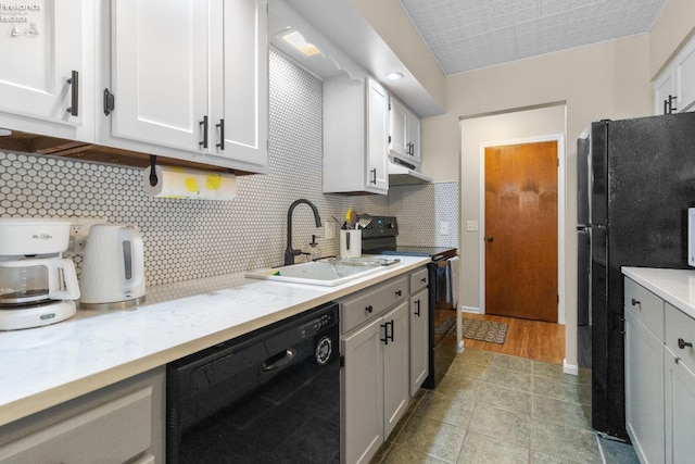 kitchen featuring backsplash, sink, black appliances, light tile patterned floors, and white cabinets