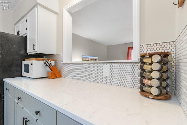 kitchen featuring white cabinetry and backsplash