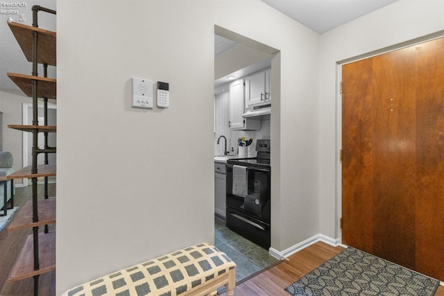 kitchen with black range with electric stovetop, decorative backsplash, sink, and dark hardwood / wood-style flooring