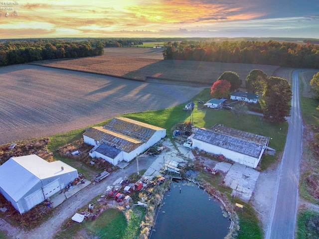 aerial view at dusk featuring a water view