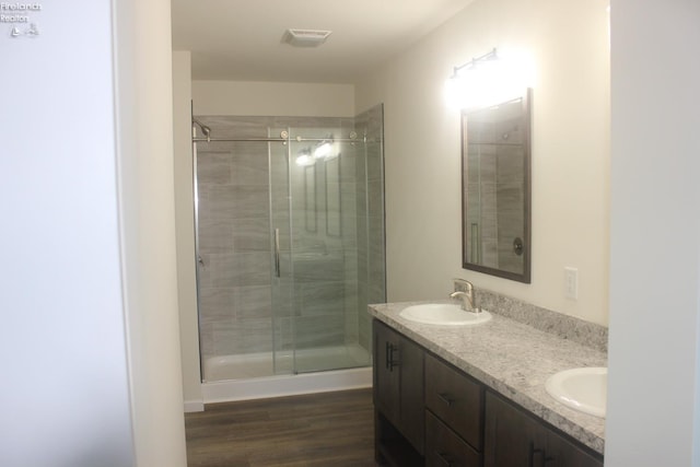 bathroom with vanity, an enclosed shower, and wood-type flooring