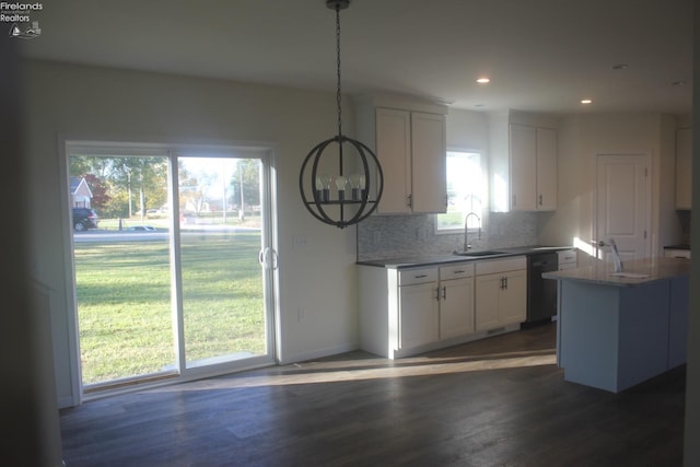 kitchen featuring dishwasher, white cabinets, decorative light fixtures, and dark hardwood / wood-style flooring