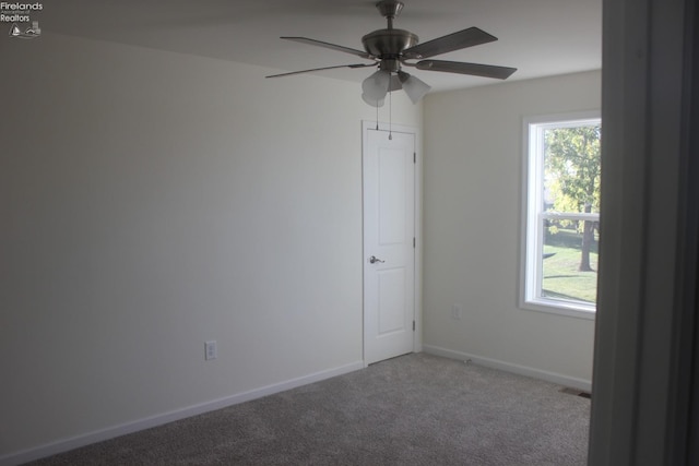 carpeted empty room featuring a healthy amount of sunlight and ceiling fan