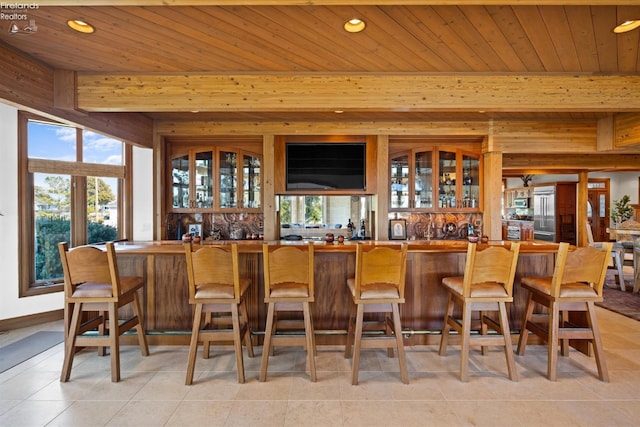 bar featuring light tile patterned flooring and wooden ceiling