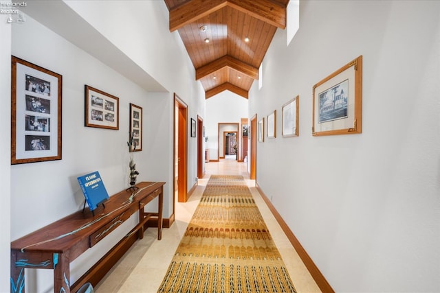 hall featuring beam ceiling, high vaulted ceiling, and wooden ceiling