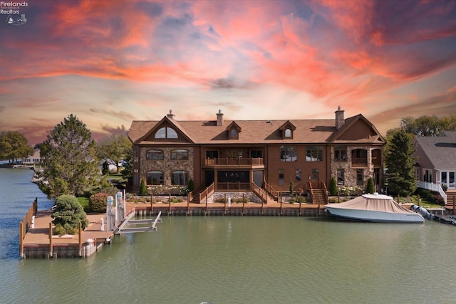 back house at dusk featuring a water view