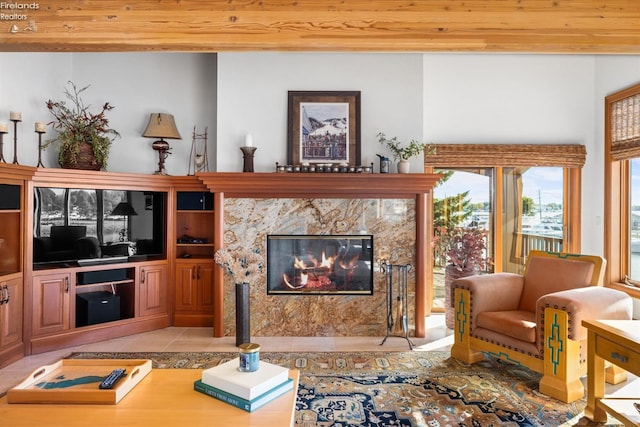 living room featuring light tile patterned flooring and a high end fireplace