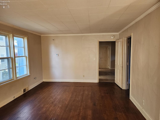 unfurnished room featuring dark wood-type flooring and crown molding