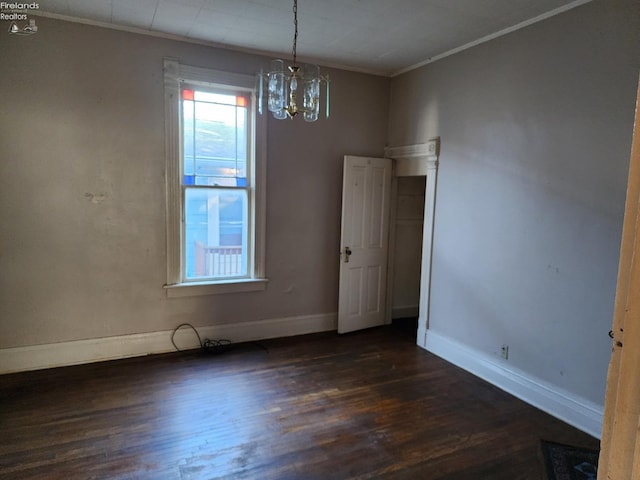 unfurnished dining area featuring crown molding, dark hardwood / wood-style flooring, and a chandelier