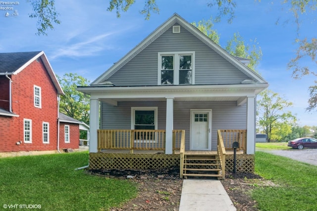 view of front of house featuring covered porch and a front yard