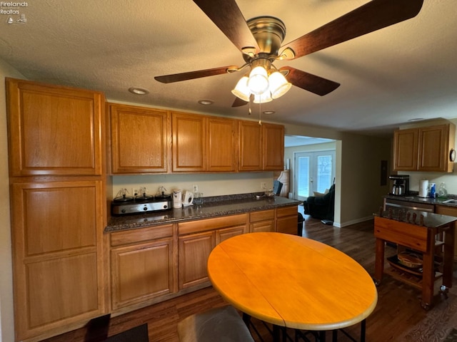 kitchen featuring dark wood-type flooring, ceiling fan, and a textured ceiling