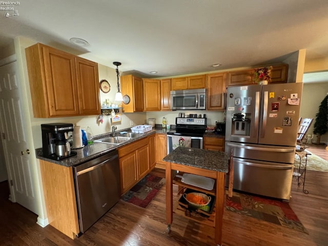 kitchen featuring sink, appliances with stainless steel finishes, decorative light fixtures, and dark hardwood / wood-style flooring