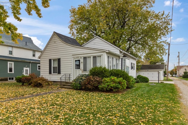 bungalow-style house with a garage and a front lawn