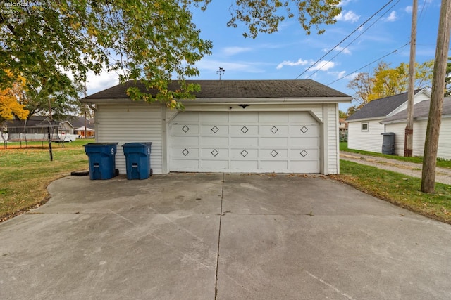 garage with a yard and a trampoline