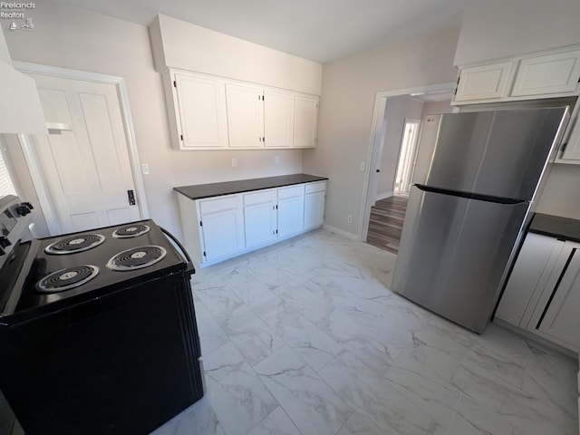 kitchen with white cabinets, range with electric stovetop, and stainless steel fridge