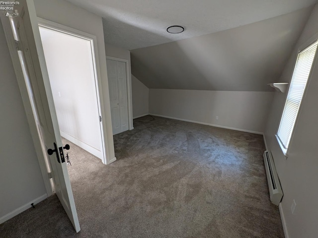 bonus room featuring lofted ceiling, a baseboard heating unit, and dark colored carpet