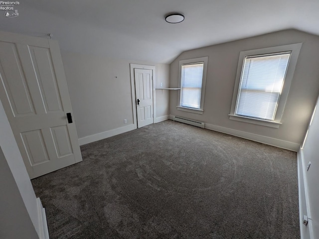 additional living space with dark carpet, a baseboard radiator, and vaulted ceiling