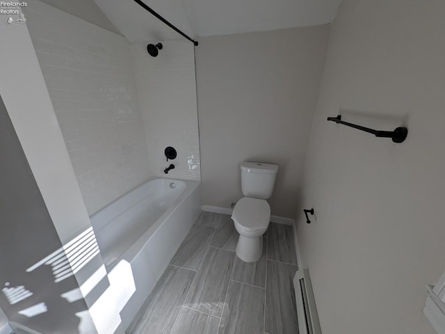 bathroom featuring toilet, baseboard heating, and tiled shower / bath