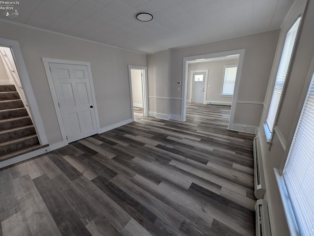 unfurnished living room with crown molding and dark hardwood / wood-style floors