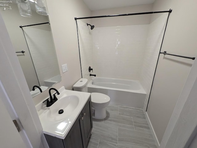 full bathroom with vanity, tiled shower / bath combo, and toilet