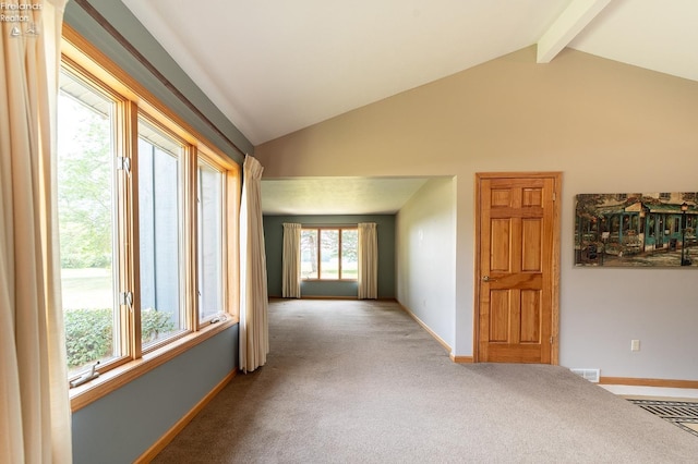 carpeted empty room featuring vaulted ceiling with beams