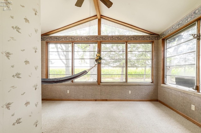 unfurnished sunroom featuring ceiling fan and vaulted ceiling with beams