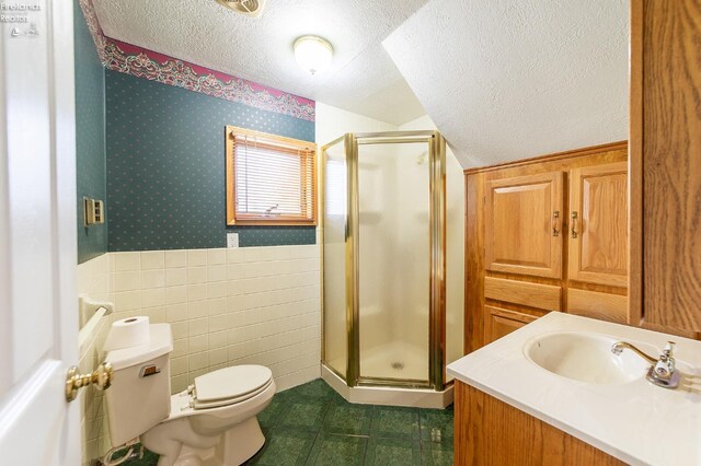 bathroom with a shower with door, toilet, a textured ceiling, and vanity