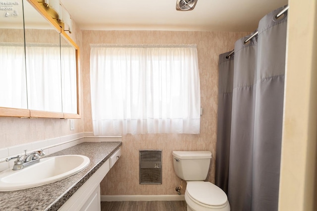 bathroom featuring toilet, hardwood / wood-style floors, curtained shower, and vanity