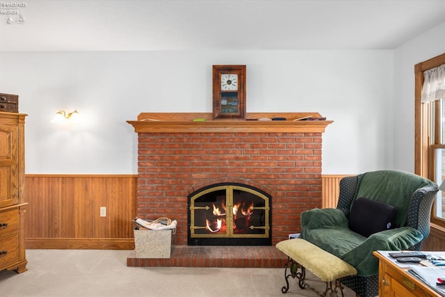 living area with a brick fireplace, wooden walls, and light colored carpet