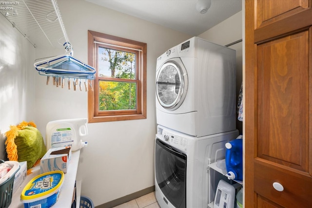 clothes washing area with stacked washer / dryer and light tile patterned floors