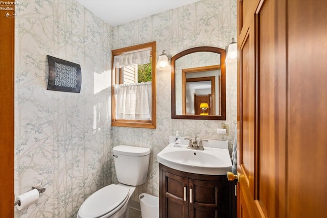 bathroom with toilet, vanity, and tile walls