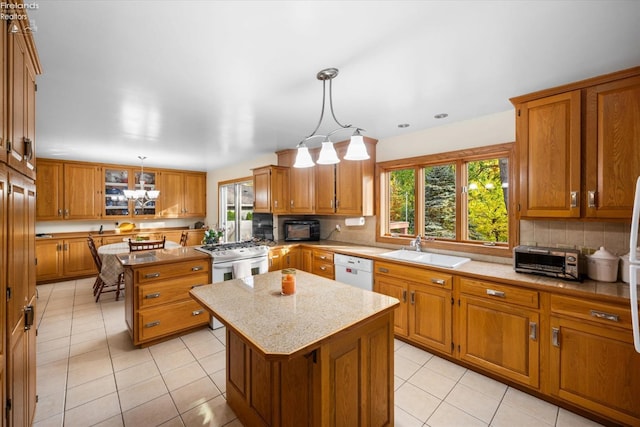 kitchen with sink, a center island, pendant lighting, and a chandelier