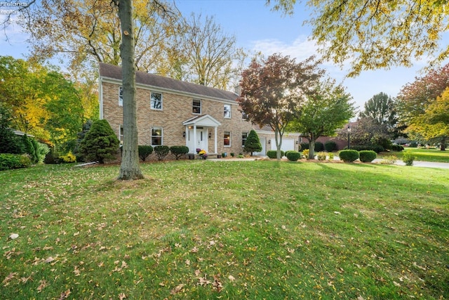 colonial inspired home with a front yard and a garage