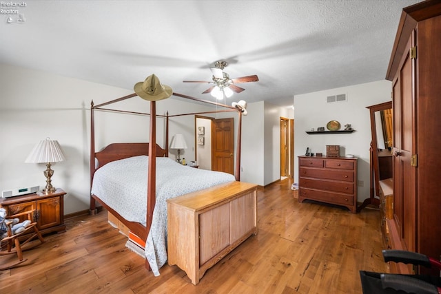 bedroom featuring dark hardwood / wood-style floors, a textured ceiling, and ceiling fan