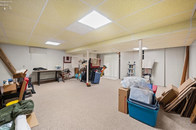 basement with a drop ceiling and carpet