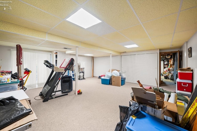 workout area with a paneled ceiling and carpet