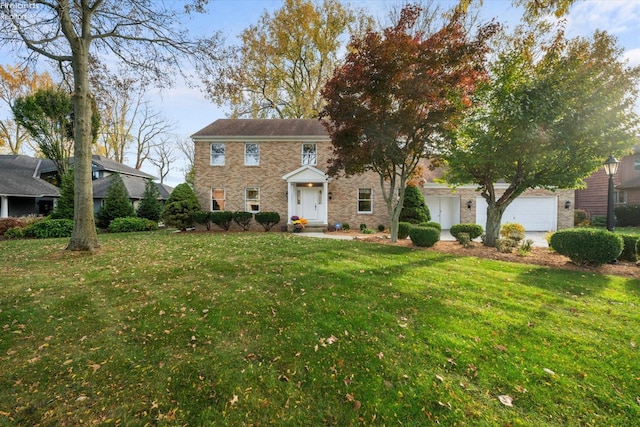 colonial inspired home featuring a front yard and a garage