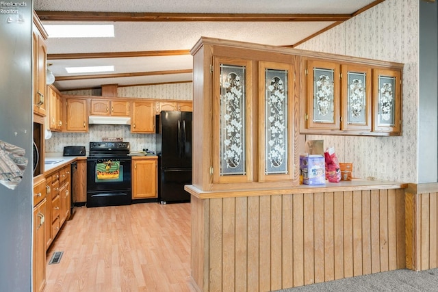 kitchen featuring black appliances, crown molding, a textured ceiling, vaulted ceiling, and light hardwood / wood-style flooring