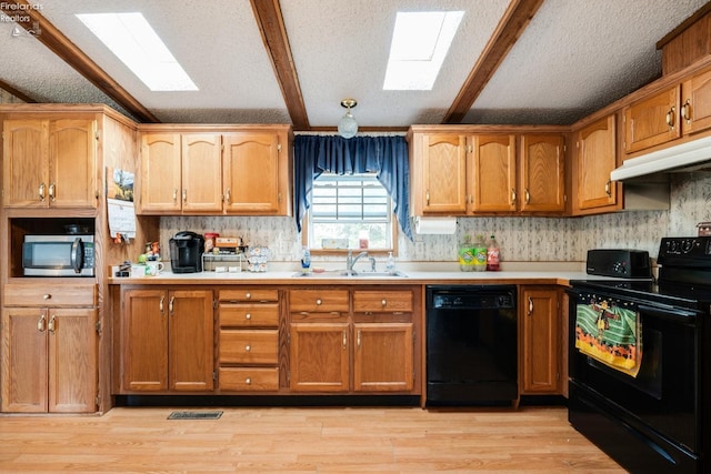 kitchen with beamed ceiling, sink, black appliances, a textured ceiling, and light wood-type flooring